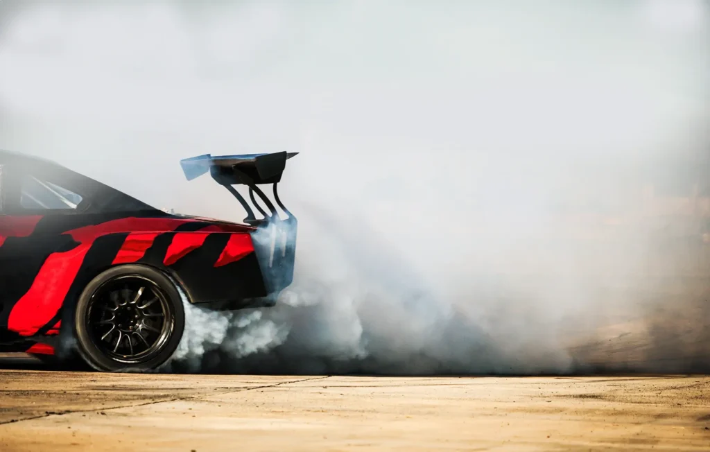 Sport car wheel spins in a cloud of smoke on a high-speed track in North Carolina.
